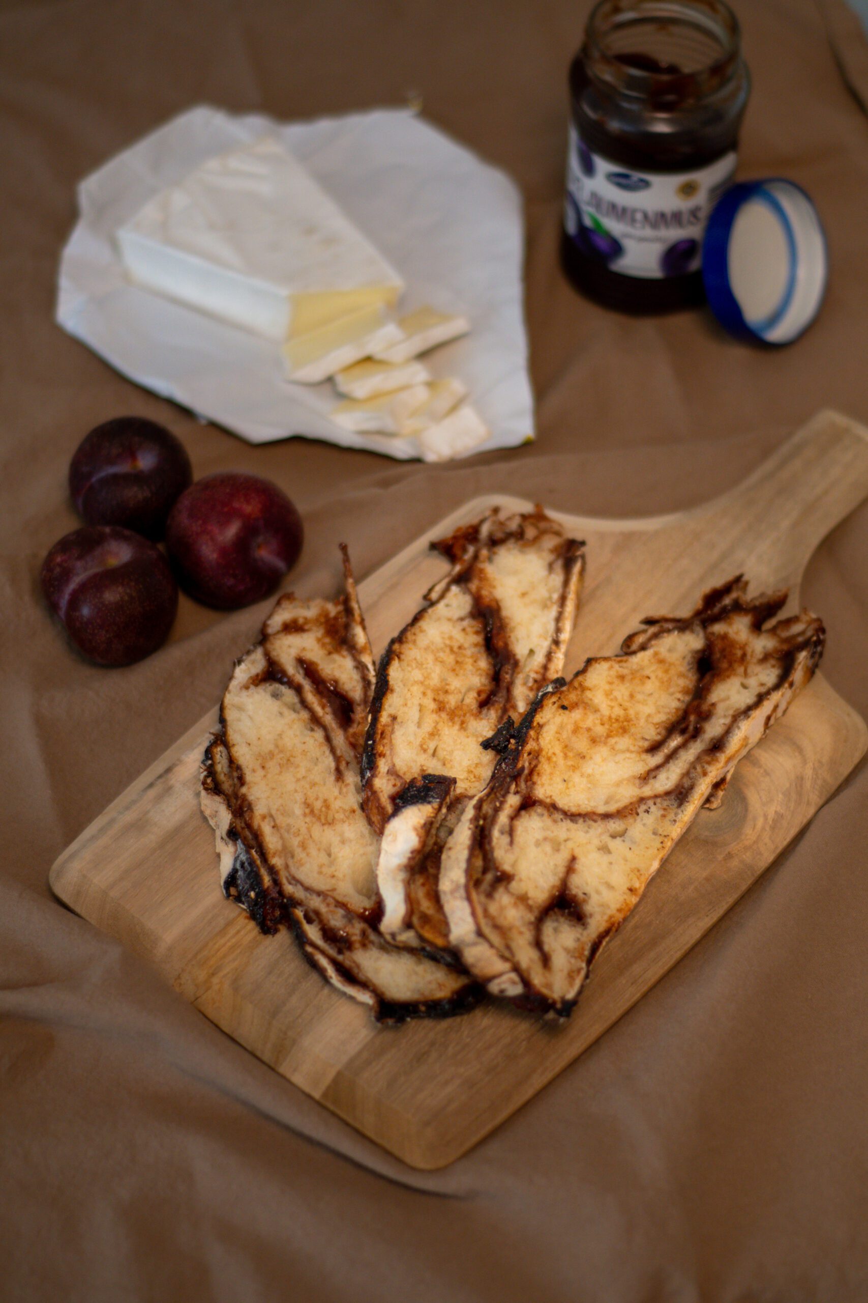 Homemade sourdough plum bread slices with jam swirls on wooden board